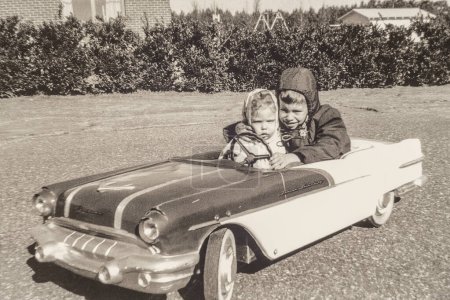 Elektroautos sind nichts Neues! Dieses Foto des Fotografen und seiner Schwester aus dem Jahr 1957 zeigt die Vorteile eines Pontiac-Händlers für einen Vater. Foto ist sehr körnig