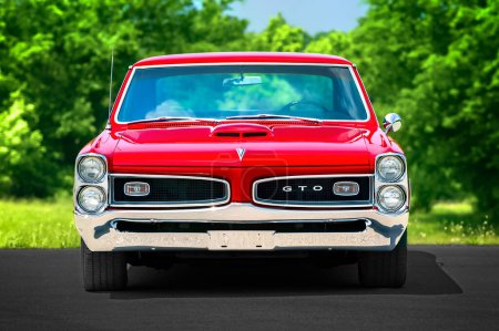 Foto de Maryville, Tennessee, Estados Unidos - 12 de mayo de 2011: Una imagen de largo teleobjetivo de un GTO rojo brillante de 1966 con tonos y detalles sencillos. - Imagen libre de derechos