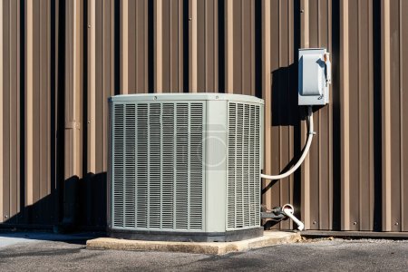 Photo for Horizontal shot of a commercial air conditioning unit with electrical box outside a retail shopping center. - Royalty Free Image
