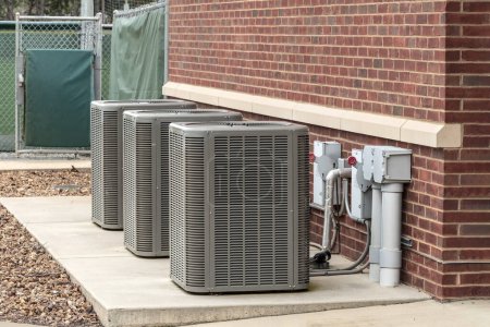 Photo for Horizontal shot of three air conditioners outside of a sports complex. - Royalty Free Image