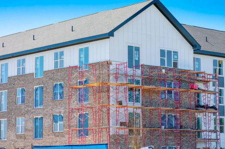 Téléchargez les photos : Plan horizontal d'échafaudages de briques autour d'un nouvel immeuble à appartements de plusieurs étages. - en image libre de droit