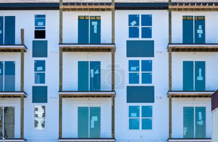 Téléchargez les photos : Vue horizontale d'un immeuble d'appartements de plusieurs étages en construction dans une banlieue en plein essor. - en image libre de droit