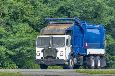 Photo for Horizontal shot of a blue and white garbage truck on the highway. - Royalty Free Image