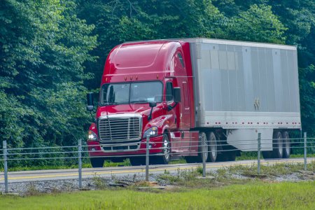 Photo for Horizontal shot of a red eighteen wheeler on a stretch of rural interstate. - Royalty Free Image