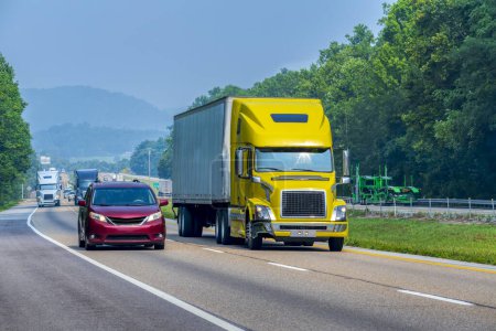 Photo for Horizontal shot of a yellow tractor trailer traveling on a Tennessee interstate highway. - Royalty Free Image