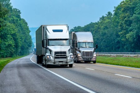 Téléchargez les photos : Plan horizontal de deux semi-camions sur l'autoroute avec trafic léger. - en image libre de droit