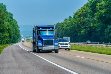 Photo for Horizontal shot of a heavy blue dump truck on an interstate highway with copy space. - Royalty Free Image