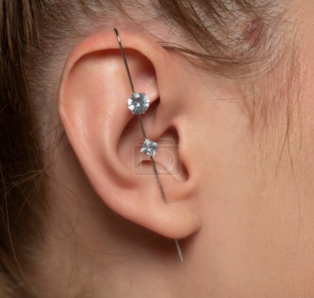 Foto de Perforación de la oreja femenina sin perforar la hélice. - Imagen libre de derechos