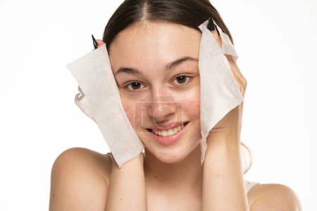 Foto de Beautifu joven mujer limpiando su cara con una toallita de bebé. - Imagen libre de derechos