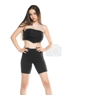 Photo for Young woman in black shorts and top posing in the studio on white background. - Royalty Free Image