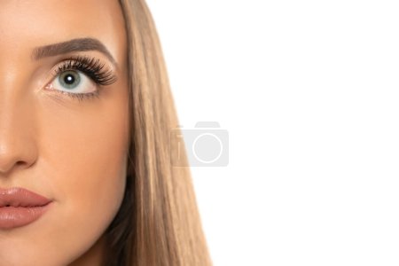 Téléchargez les photos : Beauté oeil féminin avec boucle longs faux cils sur un fond de studio blanc - en image libre de droit
