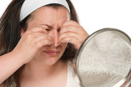 Foto de Mujer gordita nerviosa con diadema apretar granos en la nariz. - Imagen libre de derechos