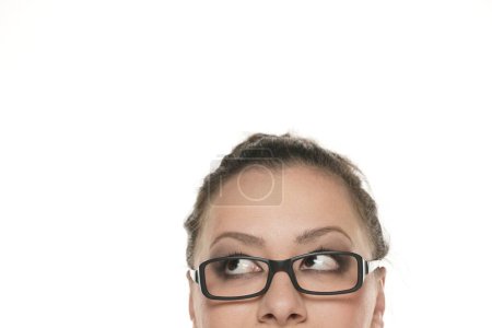 Foto de Medio retrato de una joven gordita con gafas mirando hacia arriba. - Imagen libre de derechos