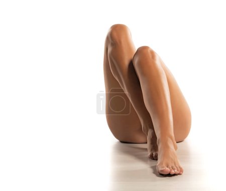 Photo for Beautiful and sexy crossed female legs on white floor and studio background - Royalty Free Image