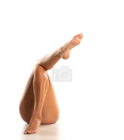 Photo for Beautiful and sexy crossed female legs on white floor and studio background - Royalty Free Image