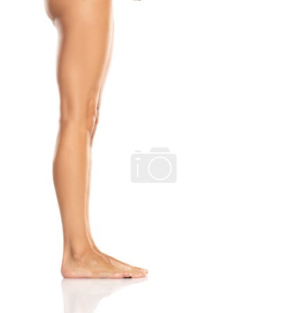 Téléchargez les photos : Side profile view of a beautiful women's feet and legs on white studio background - en image libre de droit