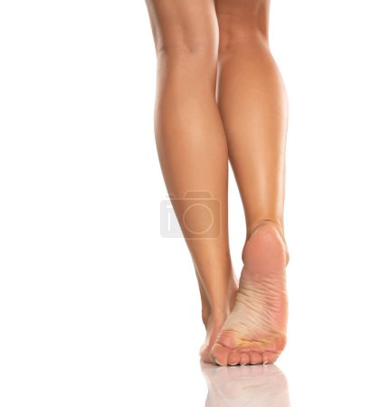 Foto de Pretty woman legs and sole feet on white studio background - Imagen libre de derechos