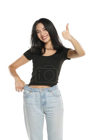 Photo for Weight loss happy woman showing thumbs up, isolated on a white studio background. Slim Body - Royalty Free Image