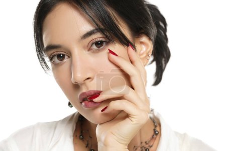 Foto de Mujer con esmalte de uñas rojo sobre un fondo de estudio blanco. de cerca - Imagen libre de derechos
