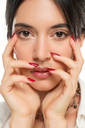Téléchargez les photos : Femme montre son vernis à ongles rouge sur fond de studio blanc. gros plan - en image libre de droit