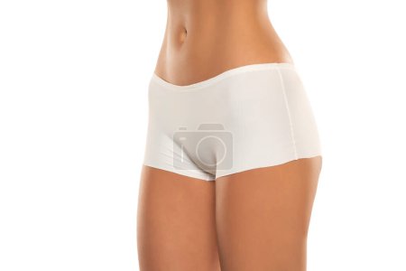 Photo for Mid section of woman wearing white briefs,  front view on a white studio background. - Royalty Free Image