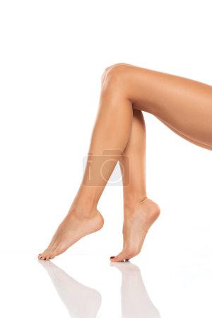 Photo for Side view of beautifully cared women's legs and feet on white studio background. - Royalty Free Image