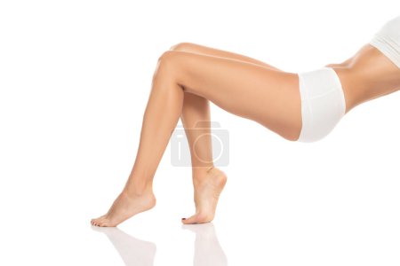Téléchargez les photos : Side view of beautifully cared women's legs and feet on white studio background. - en image libre de droit