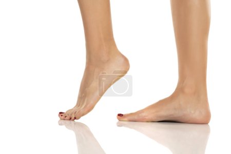 Téléchargez les photos : Side view of a beautifully cared female feet on a white studio background. - en image libre de droit