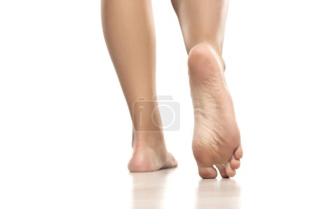 Foto de Vista posterior de una mujer bellamente cuidada pies desnudos sobre un fondo de estudio blanco. - Imagen libre de derechos