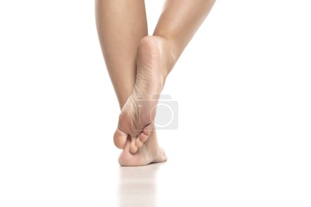 Foto de Vista posterior de una mujer bellamente cuidada pies desnudos sobre un fondo de estudio blanco. - Imagen libre de derechos