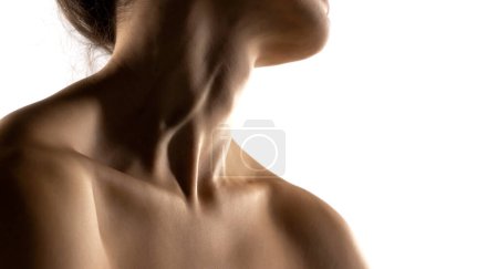 Photo for The close-up of a young woman's neck and shoulders in the shadow on white studio background - Royalty Free Image