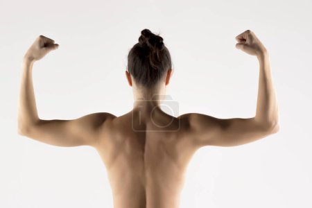 Photo for A young woman's back and arms  in the shadow on white studio background - Royalty Free Image