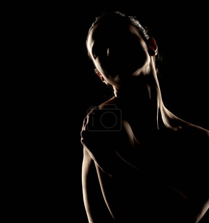 Foto de Sensual silueta de retrato de mujer hermosa en contraluz sobre un fondo de estudio negro - Imagen libre de derechos