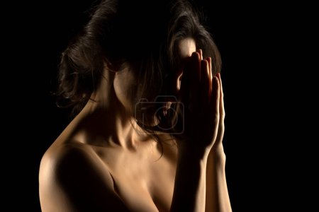 Téléchargez les photos : Silhouette de jeune femme indiscret sur fond de studio noir - en image libre de droit