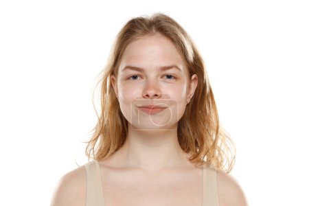 Téléchargez les photos : Portrait de jeune belle femme blonde sans maquillage sur fond de studio blanc - en image libre de droit