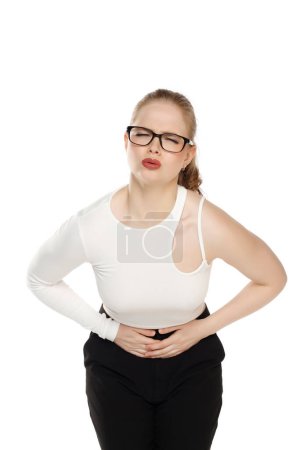 Foto de Mujer que tiene dolor de estómago, doblar y tomarse de la mano en el vientre, malestar de los calambres menstruales en un fondo blanco estudio - Imagen libre de derechos