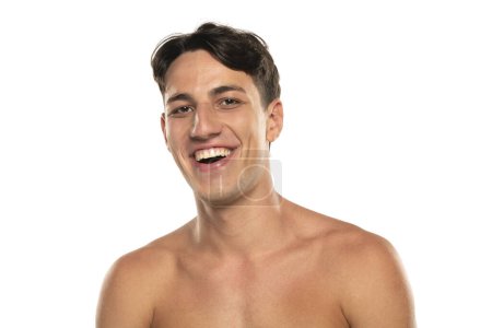Téléchargez les photos : Gros plan portrait de heureux homme torse nu 20s regardant caméra isolé sur fond de studio blanc - en image libre de droit