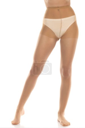 Photo for Woman wearing tights isolated on white, closeup of legs on a white studio background. Front view - Royalty Free Image