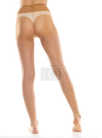Foto de Mujer con medias aisladas en blanco, primer plano de las piernas sobre un fondo de estudio blanco. Atrás, vista trasera - Imagen libre de derechos