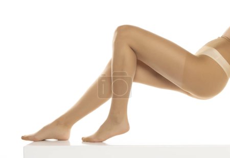 Foto de Mujer con mallas posando aisladas sobre blanco, primer plano de las piernas sobre un fondo de estudio blanco. Perfil, vista lateral - Imagen libre de derechos