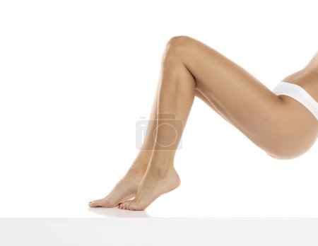 Photo for Perfect female legs in underwear on a white studio background. Side, profile view - Royalty Free Image