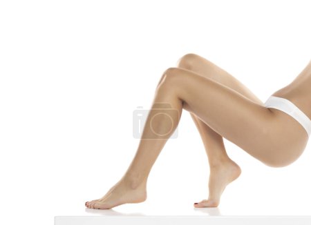 Photo for Perfect female legs in underwear on a white studio background. Side, profile view - Royalty Free Image