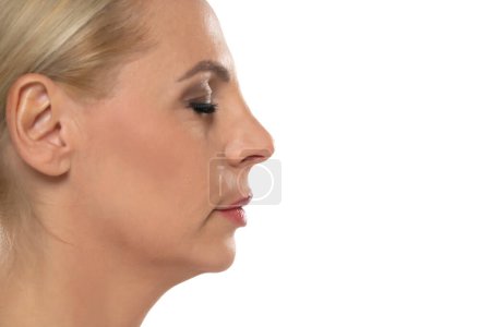 Foto de Perfil de la mujer rubia de mediana edad con cirugía de nariz sobre fondo blanco de estudio - Imagen libre de derechos