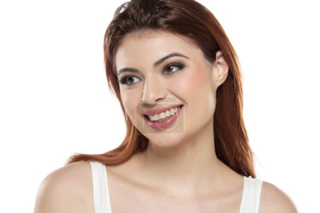 Foto de Hermosa joven sonriente pelirroja mujeres con maquillaje y pelo largo en un fondo de estudio blanco. - Imagen libre de derechos