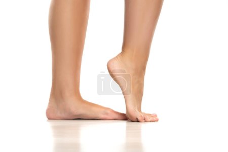Téléchargez les photos : Side view of a beautifully cared female feet on a white studio background. - en image libre de droit