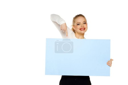 Photo for Banner of young happy blonde woman feeling happiness and pointing blue Empty white canvas frame for text or advertising isolated on white studio background - Royalty Free Image