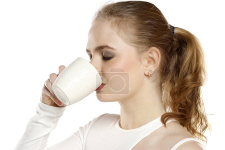 Foto de Hermosa joven rubia bebiendo café en el fondo blanco del estudio - Imagen libre de derechos