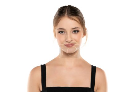 Téléchargez les photos : Élégance rayonnante : Portrait d'une jeune femme souriante avec maquillage, updo et contact visuel sur fond de studio blanc - en image libre de droit