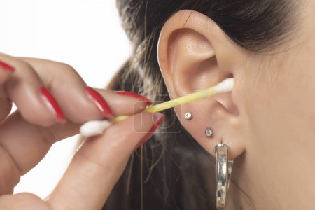 Photo for A woman cleaning her ear with cotton swab - Royalty Free Image