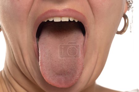 Téléchargez les photos : Gros plan de la bouche ouverte d'une femme avec sa langue qui sort de façon ludique - en image libre de droit